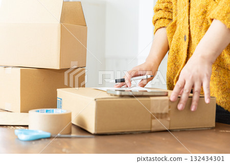 Hands of a woman packing Hands of a woman packing 132434301