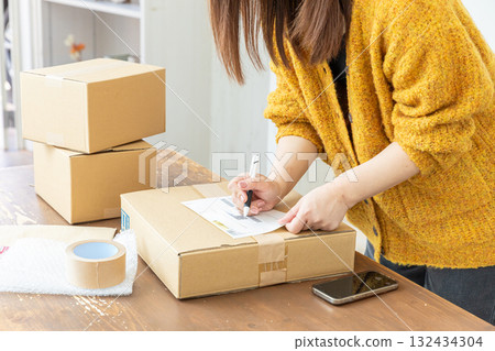 Hands of a woman packing 132434304