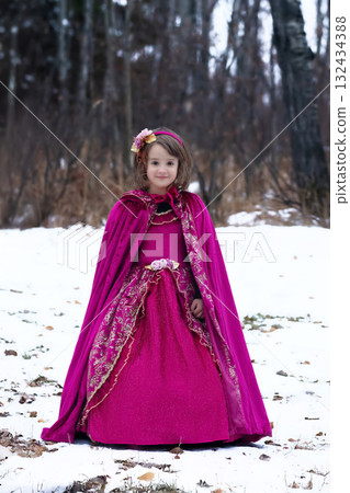 Girl in a Halloween costume of a princess in woods, long red dress. 132434388