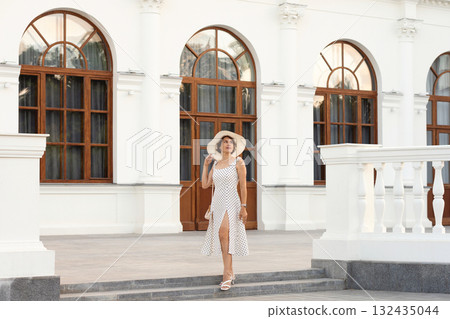 Woman in Polka Dot Dress Descends Steps at Neoclassical Facade Woman in Polka Dot Dress Descends Steps at Neoclassical Facade 132435044