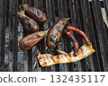 Grilled eggplants and sausages on a rustic barbecue grill 132435117