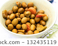 Green olives and pickles in a ceramic bowl 132435119