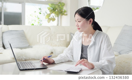 一位自由職業女性正在做會計計算 一位自由職業女性正在做會計計算 132436380