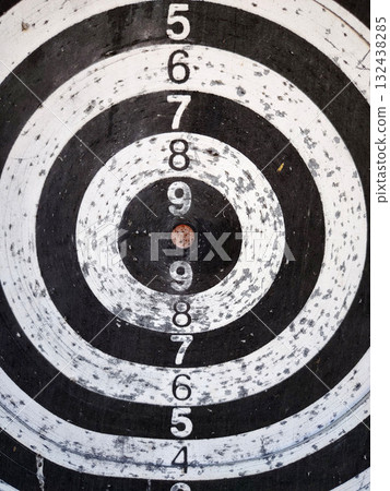 Worn black and white target board with numbers. 132438285