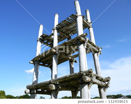 A large, post-hole building towering against the blue sky 132439015