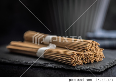 Buckwheat soba noodles on black table. 132440425