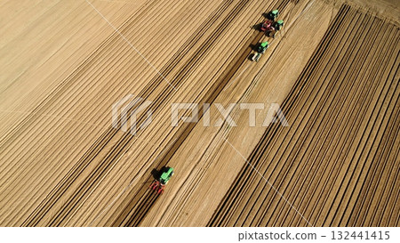Aerial View of Tractors Preparing Farmland for Planting Season 132441415