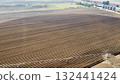 Aerial View of Tractors Preparing Farmland for Planting Season 132441424