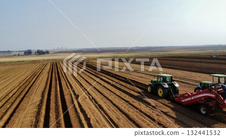 Aerial View of Tractors Preparing Farmland for Planting Season 132441532