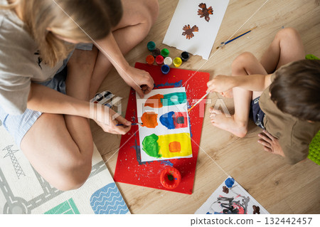 Mother and child painting together on colorful art project at home 132442457