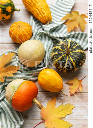Autumn gourds pumpkins and fall leaves on wooden background 132442545