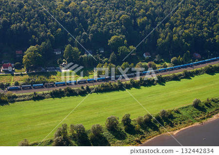 Aerial view of landscape with freight train on railway, green fields and forest Aerial view of landscape with freight train on railway, green fields and forest 132442834