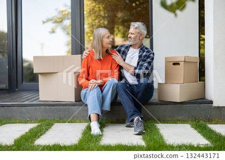 Mature couple resting after moving to a new house and feeling contented 132443171