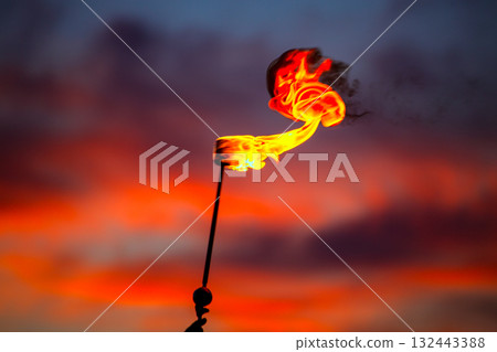 Fire torch at sunset sky with red clouds 132443388