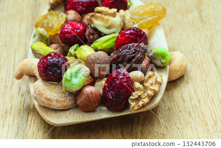 Varieties of dried fruits and nuts on wooden spoon. Varieties of dried fruits and nuts on wooden spoon. 132443706