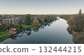 London, Teddington: Calm River Thames flowing through Teddington district in London city, reflecting trees and houses on a peaceful autumn morning. Drone flight London, Teddington: Calm River Thames flowing through Teddington district in London city, reflecting trees and houses on a peaceful autumn morning. Drone flight 132444215