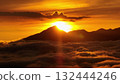 Bali island, Mount Batur volcano silhouetted against a vibrant golden sunrise, with a sea of rolling clouds filling the valley below, creating a serene and breathtaking aerial landscape panorama Bali island, Mount Batur volcano silhouetted against a vibrant golden sunrise, with a sea of rolling clouds filling the valley below, creating a serene and breathtaking aerial landscape panorama 132444246