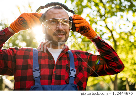 Portrait of man gardener wearing goggles and earmuffs Portrait of man gardener wearing goggles and earmuffs 132444670