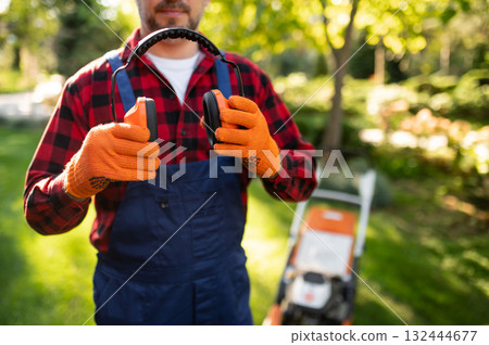 Unrecognizable man gardener holding protective earmuffs 132444677