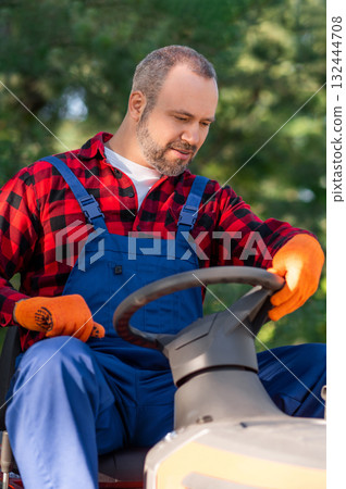 Male landscaper behind steering wheel of utility truck 132444708
