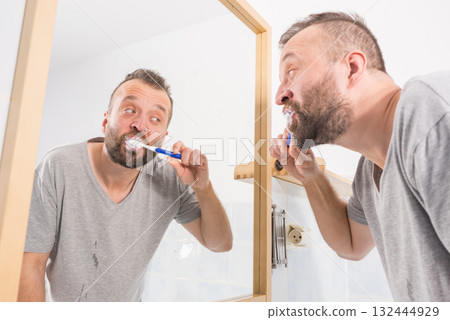 Man brushing his teeth in bathroom 132444929