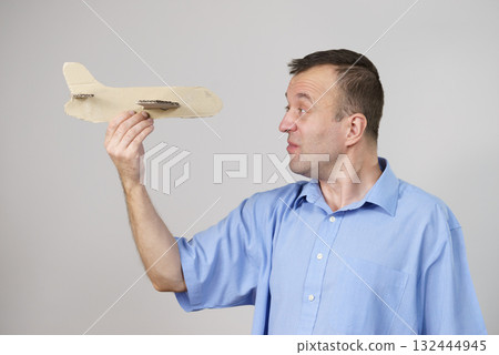 Fly fear. Man holding airplane in hand Fly fear. Man holding airplane in hand 132444945