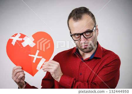 Sad adult man holding broken heart 132444950