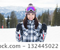 Smiling woman on the slopes of a snowy mountain 132445022