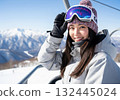 Smiling woman on a chairlift in a snowy mountain 132445024
