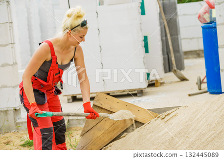 Woman using shovel on constriction site 132445089