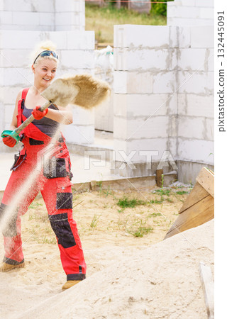 Woman using shovel on constriction site Woman using shovel on constriction site 132445091