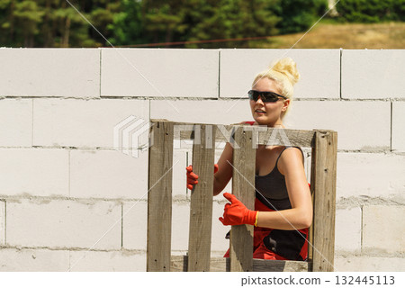 Woman working with pallets on construction site 132445113