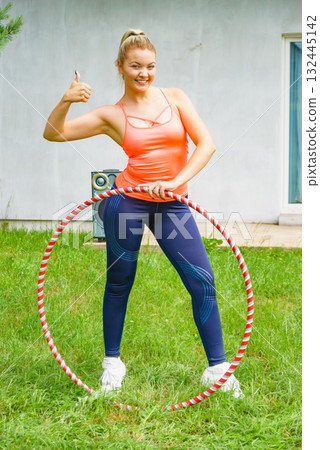 Young woman with hoola hoop outdoors 132445142