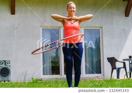 Young woman with hoola hoop outdoors Young woman with hoola hoop outdoors 132445143