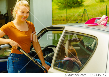 Cleaning car interior with vacuum cleaner 132445147