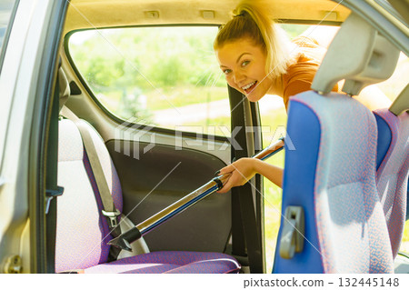 Cleaning car interior with vacuum cleaner 132445148