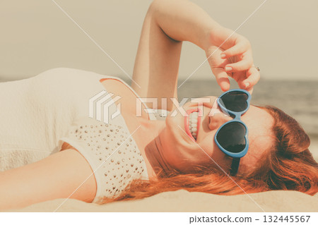 Redhead adult woman lying on beach 132445567