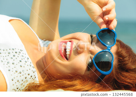 Beautiful redhaired girl in sunglasses on beach, portrait Beautiful redhaired girl in sunglasses on beach, portrait 132445568