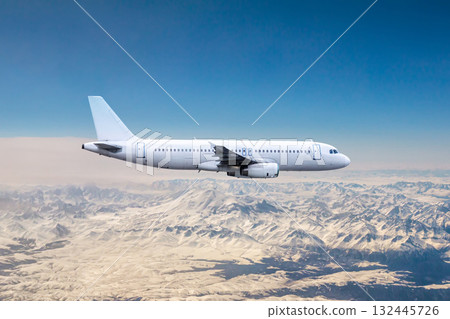White modern aircraft flying over snow covered mountains 132445726