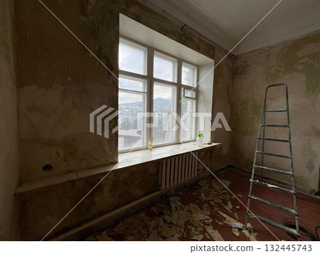 Removing wallpaper from wall during renovation in old room Removing wallpaper from wall during renovation in old room 132445743