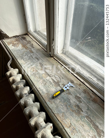 Scraper sits on wooden window sill that has peeled off old paint Scraper sits on wooden window sill that has peeled off old paint 132445753
