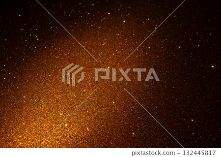 Shimmering golden glitter texture with diagonal glow and vivid sparkles fading into dark edges 132445817