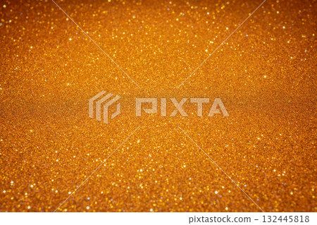 Countless golden sparkles scattered like luminous sand grains form radiant abstract background 132445818
