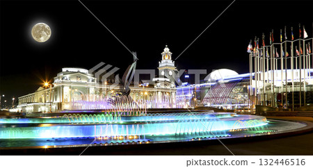 Square of  Europe, Animated fountain and Kiyevskaya railway station (written in Russian)  lit at night--  with the super moon, Moscow, Russia 132446516