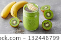 Fresh green smoothie with banana and kiwi served in a jar surrounded by fresh fruits on a gray background 132446799