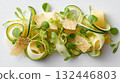 Delicate vegetable salad featuring zucchini ribbons, fresh herbs, and crispy toppings served on a white plate during a sunny afternoon 132446803
