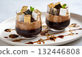 Decadent chocolate desserts topped with marshmallows and gold leaf served on a white plate 132446808