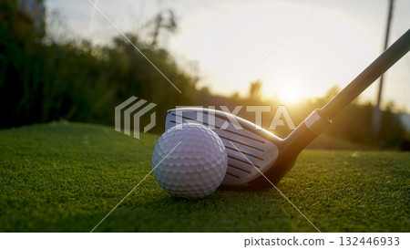 Golf clubs and balls on a green lawn in a beautiful golf course with morning sunshine. 132446933