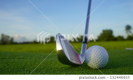 Golf clubs and balls on a green lawn in a beautiful golf course with morning sunshine. 132446935