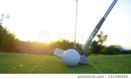 Golf clubs and balls on a green lawn in a beautiful golf course with morning sunshine. 132446936